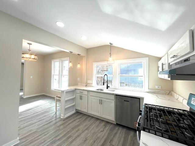 kitchen featuring appliances with stainless steel finishes, pendant lighting, white cabinets, and a sink