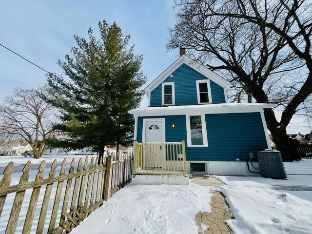 view of front facade featuring a fenced front yard and central AC