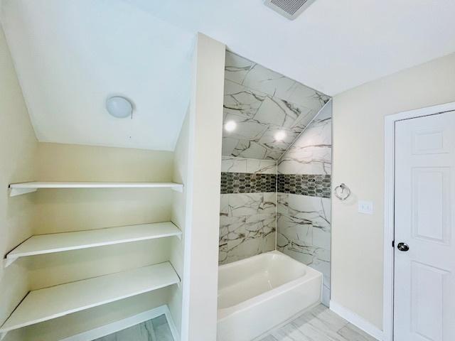 full bath with tub / shower combination, visible vents, and baseboards