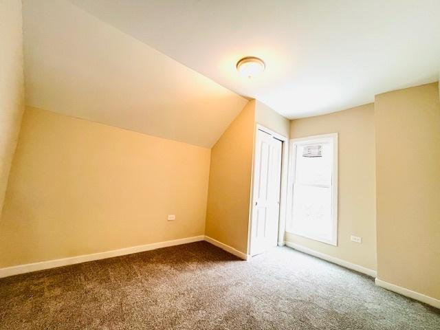 bonus room with lofted ceiling, baseboards, and carpet flooring