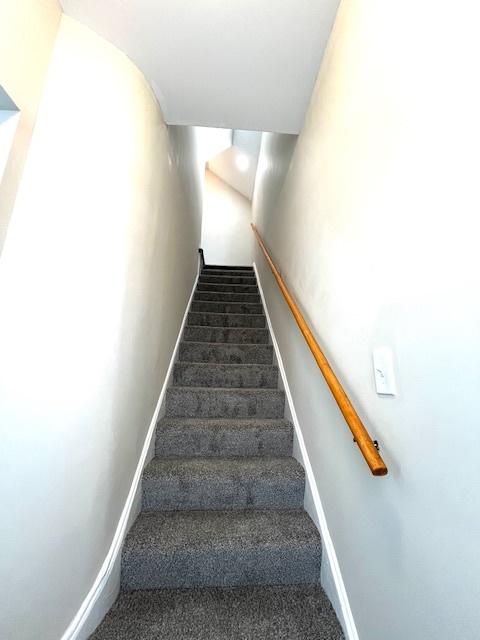 stairs featuring carpet and baseboards