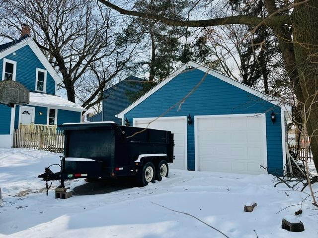 snow covered garage featuring a garage