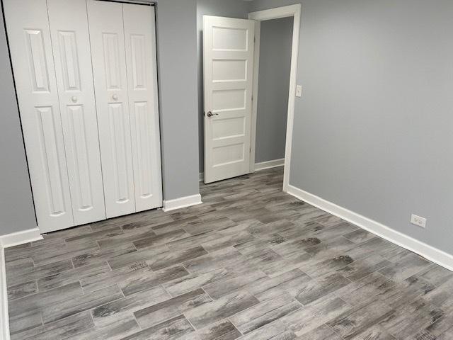 unfurnished bedroom featuring light wood-type flooring and a closet