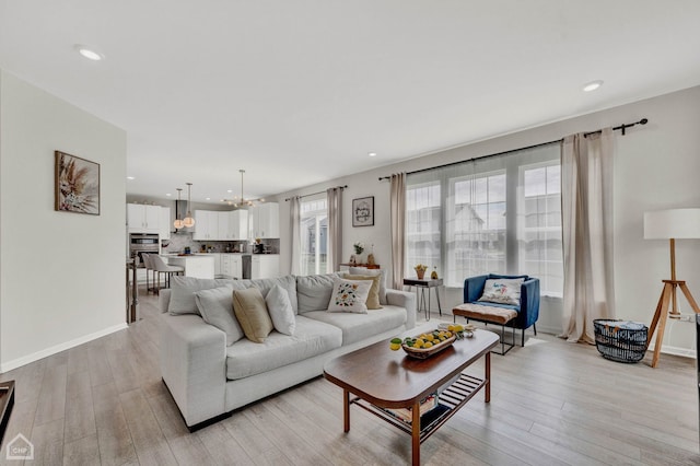 living room featuring a notable chandelier and light hardwood / wood-style floors