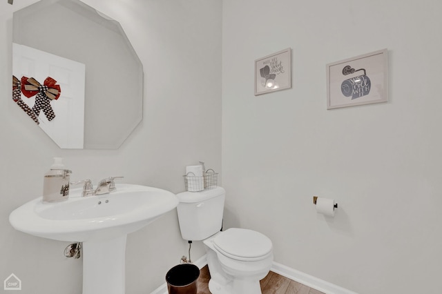 bathroom with hardwood / wood-style flooring and toilet