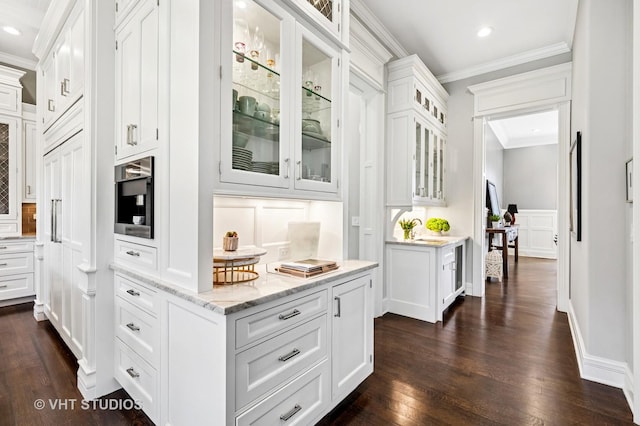interior space featuring crown molding, a decorative wall, dark wood finished floors, recessed lighting, and baseboards
