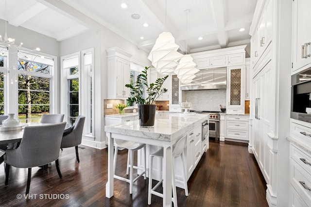 kitchen featuring white cabinets, decorative backsplash, stainless steel range, and beam ceiling