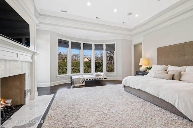 bedroom with a fireplace, baseboards, ornamental molding, and visible vents