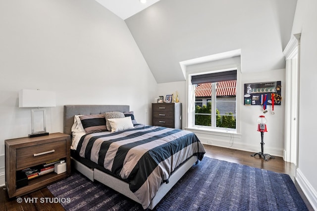 bedroom featuring baseboards, vaulted ceiling, and dark wood finished floors