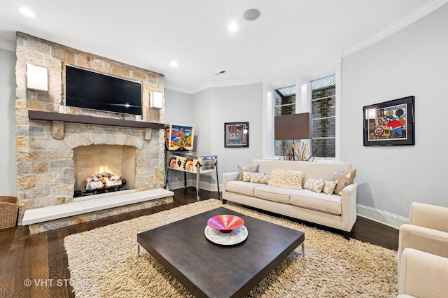 living area featuring baseboards, a stone fireplace, ornamental molding, and wood finished floors