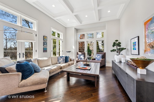 living area with dark wood-type flooring, a towering ceiling, coffered ceiling, french doors, and beam ceiling