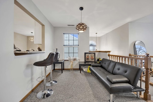 living area with carpet floors, visible vents, and baseboards