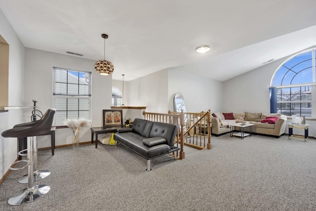 living room with visible vents, carpet, lofted ceiling, and a wealth of natural light