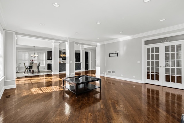 living room featuring french doors, ornate columns, ornamental molding, wood finished floors, and baseboards