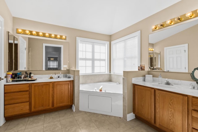 bathroom featuring tile patterned floors, a sink, a garden tub, vaulted ceiling, and two vanities