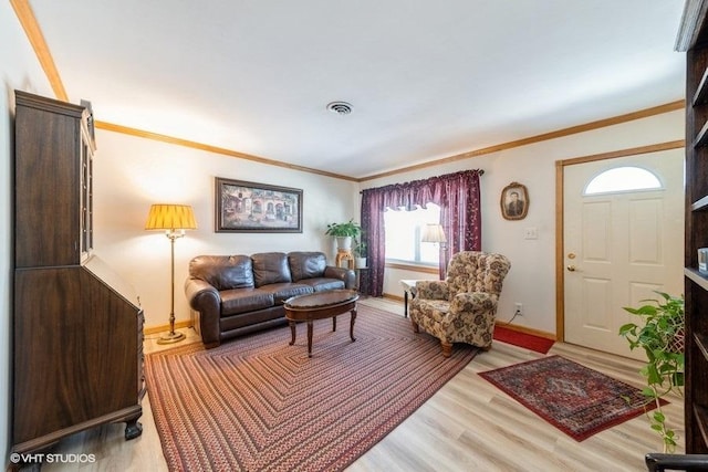 living room featuring light wood-type flooring, visible vents, crown molding, and baseboards