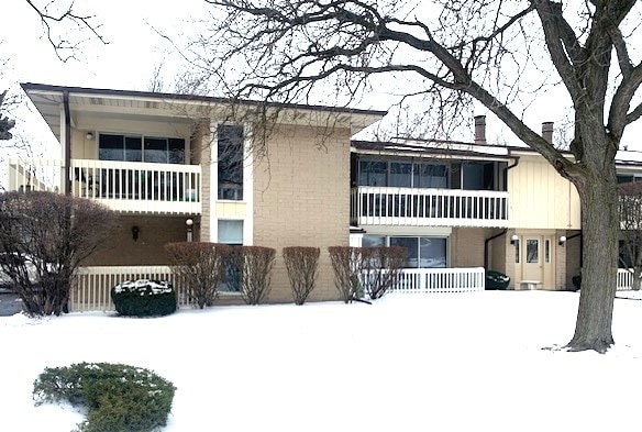 view of front of property with a chimney and a balcony