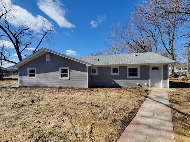 rear view of house featuring roof with shingles