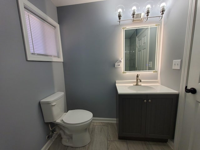 bathroom with marble finish floor, baseboards, vanity, and toilet