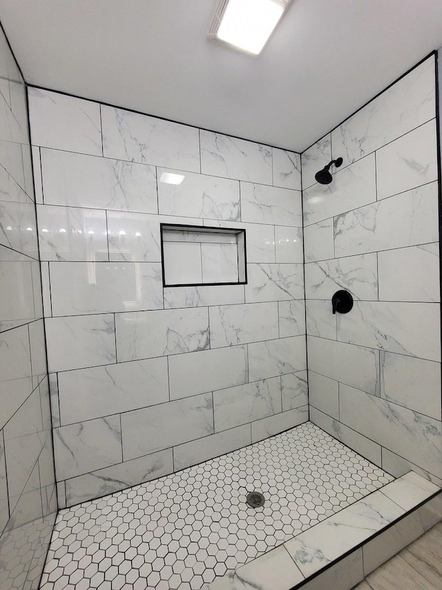 full bath with a tile shower