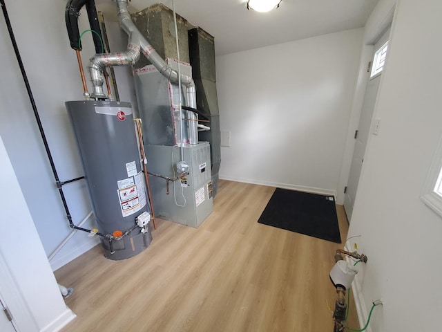 utility room featuring gas water heater and heating unit