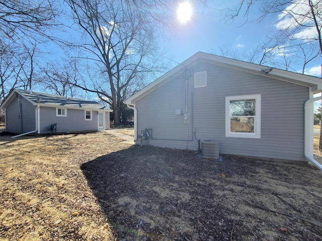 back of house with an outbuilding and central air condition unit