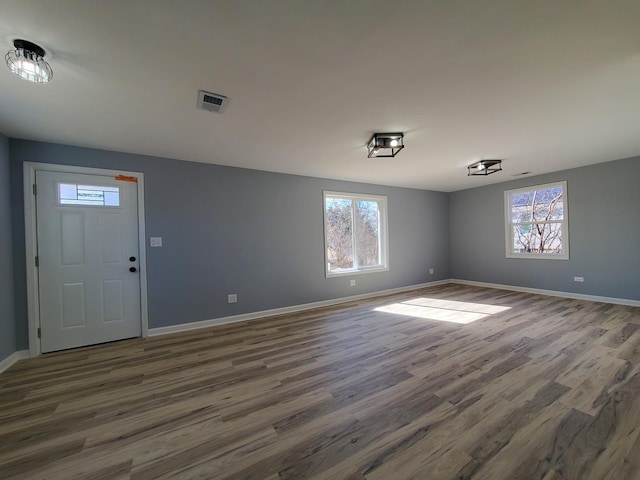 interior space featuring visible vents, baseboards, and wood finished floors