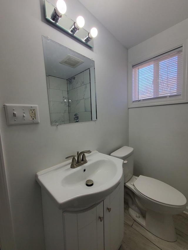 bathroom with visible vents, vanity, and toilet