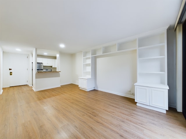 unfurnished living room featuring built in features and light hardwood / wood-style flooring