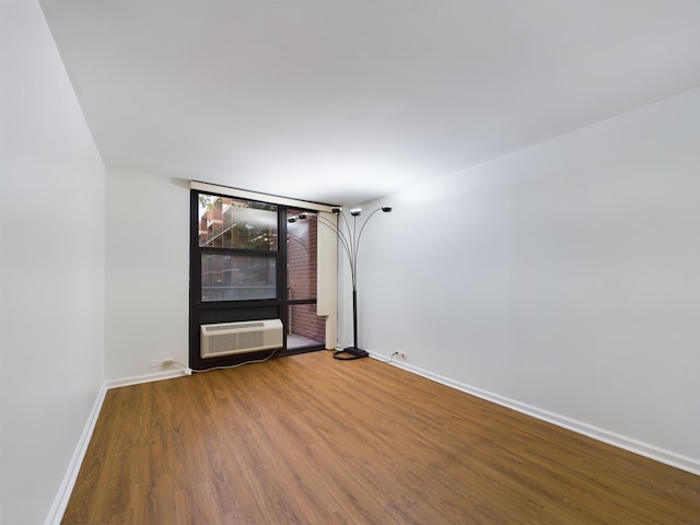 empty room featuring an AC wall unit and hardwood / wood-style flooring