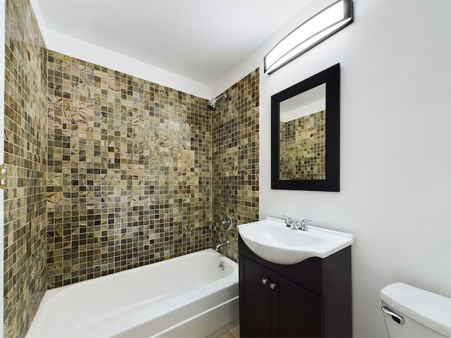 full bathroom featuring tiled shower / bath combo, vanity, and toilet