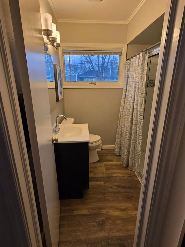 bathroom featuring toilet, ornamental molding, vanity, wood finished floors, and a shower with curtain