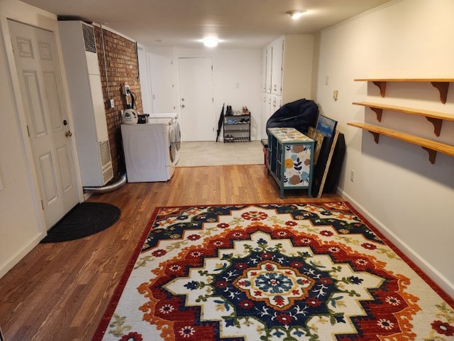 laundry area featuring laundry area, wood finished floors, washing machine and dryer, and baseboards