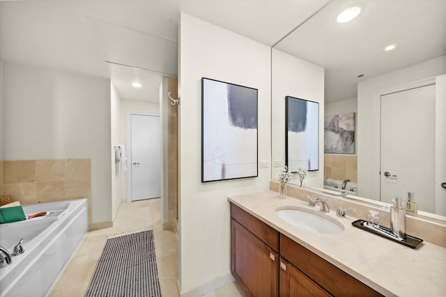 bathroom with recessed lighting, vanity, tile patterned flooring, baseboards, and a bath