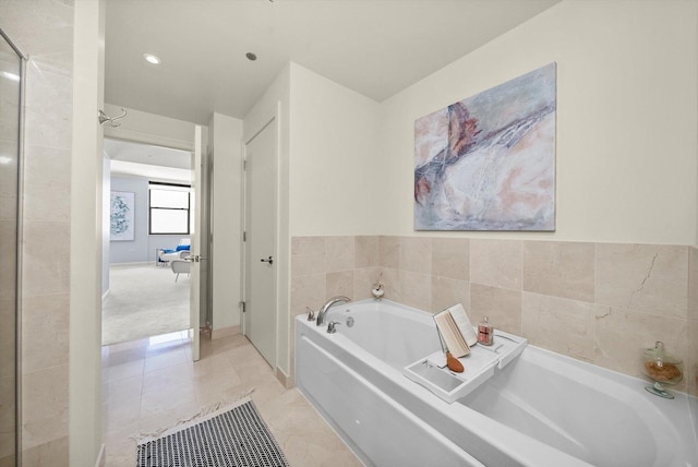 full bathroom with tile patterned floors and a bath