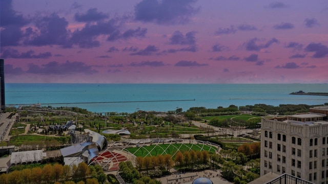 aerial view at dusk featuring a water view