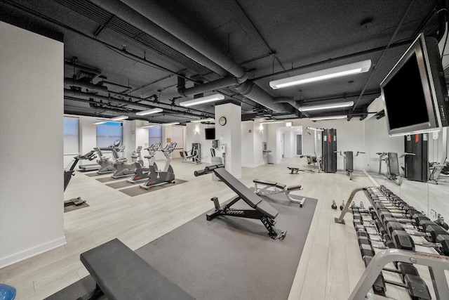 workout area featuring baseboards and wood finished floors