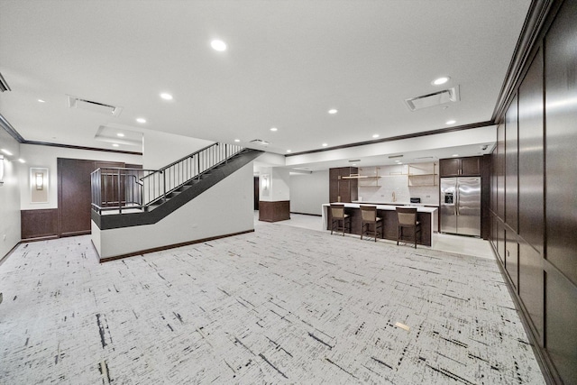 living area with ornamental molding, visible vents, and stairs