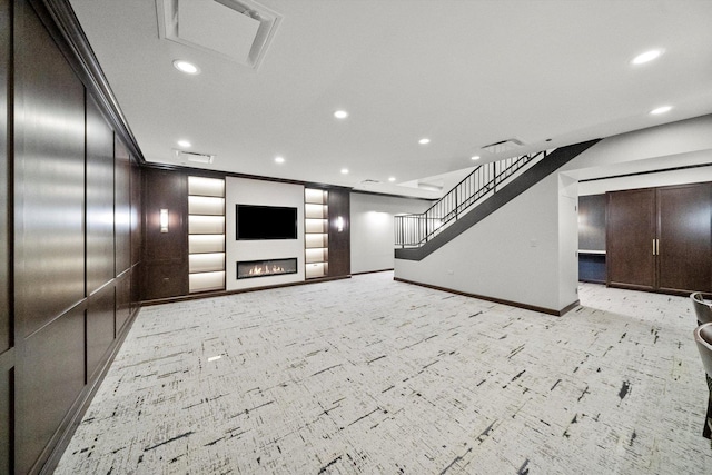 unfurnished living room with recessed lighting, visible vents, stairway, a lit fireplace, and baseboards