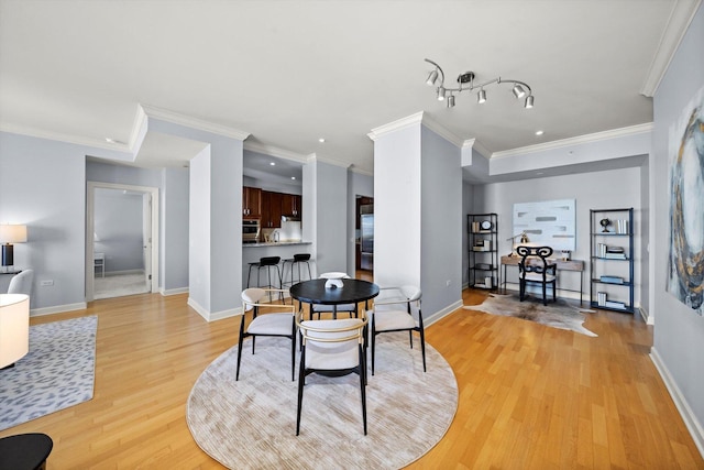 dining area with light wood-type flooring, baseboards, crown molding, and recessed lighting