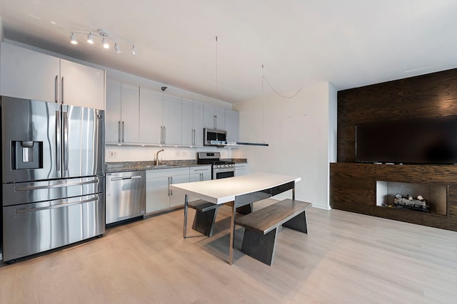 701 S Wells St Unit 3105, Chicago, IL 60607 - kitchen with stainless steel appliances, dark countertops, light wood-style floors, and a sink