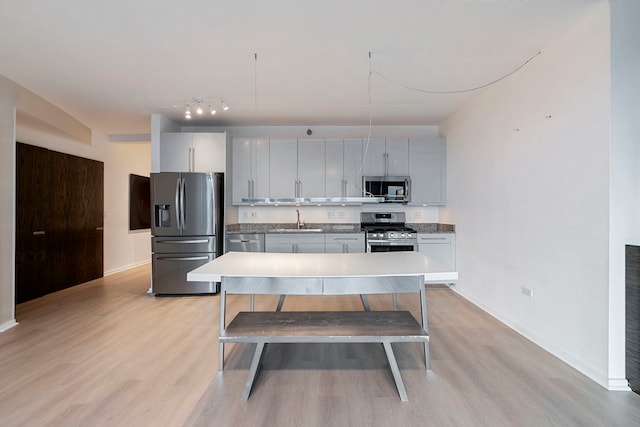 701 S Wells St Unit 3105, Chicago, IL 60607 - kitchen featuring light wood-style flooring, a sink, appliances with stainless steel finishes, a kitchen island, and baseboards