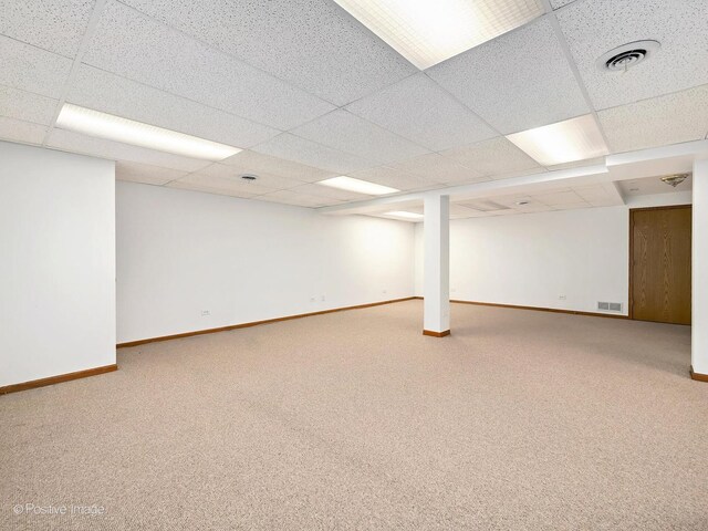 finished basement with carpet floors, baseboards, and visible vents