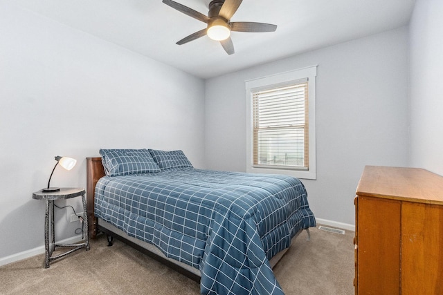 bedroom with light colored carpet, ceiling fan, visible vents, and baseboards