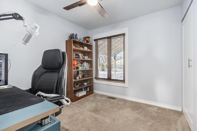 office space with visible vents, ceiling fan, light carpet, and baseboards