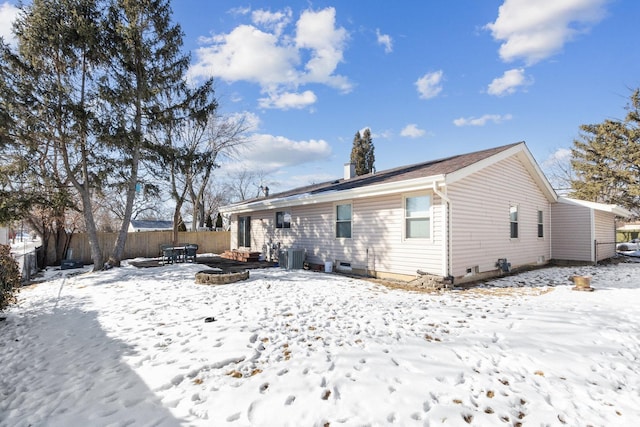 snow covered rear of property featuring a fire pit and fence