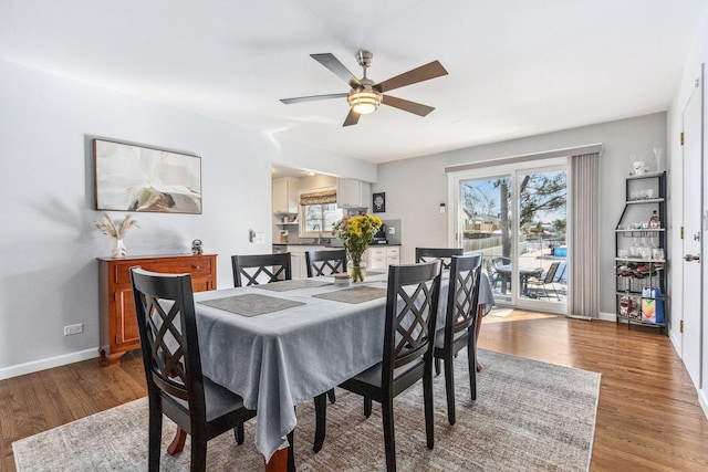 dining space featuring dark wood-type flooring, a ceiling fan, and baseboards