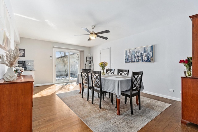 dining area with dark wood-type flooring, baseboards, and a ceiling fan