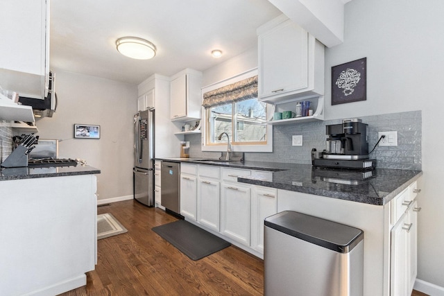 kitchen featuring open shelves, decorative backsplash, appliances with stainless steel finishes, white cabinetry, and a sink