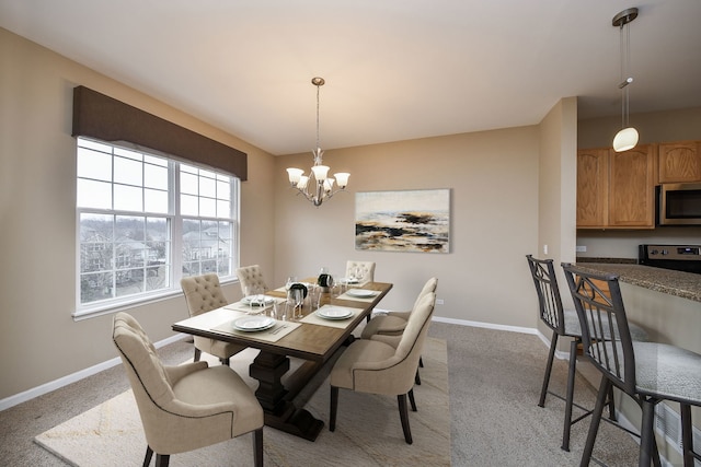 dining room featuring light carpet, baseboards, and an inviting chandelier